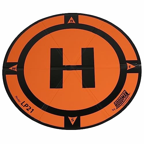 Orange circular drone landing pad with 'H' in the center and cardinal directions marked.