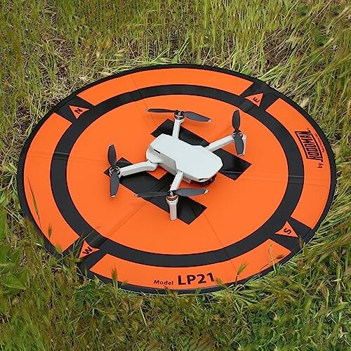 Small drone on orange landing pad in grass