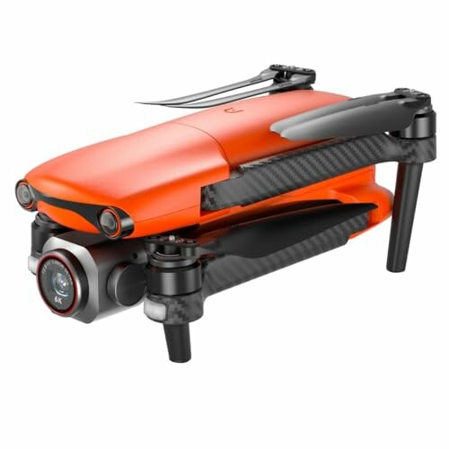 Folded orange drone with camera and propellers.
